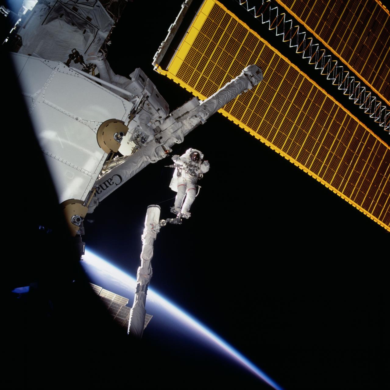 STS100-714-027 (19 April-1 May 2001) --- Astronaut Chris A. Hadfield, mission specialist representing the Canadian Space Agency (CSA), stands on the portable foot restraint (PFR) connected to the Endeavour's remote manipulator system (RMS) robotic arm, during one of the two days of extravehicular activity (EVA) on the STS-100 mission. Astronaut Scott E. Parazynski, mission specialist, is seen at left near the Spacelab pallet.