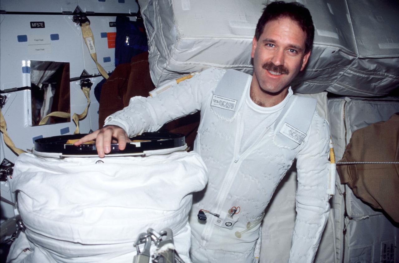 STS103-332-021  (19-27 December 1999) --- Astronaut John M. Grunsfeld, who.participated in two of the three STS-103 space walks to service the Hubble Space Telescope (HST), dons an extravehicular mobility unit (EMU) space suit for one of the walks. Grunsfeld is wearing the liquid cooling and ventilation garment that complements the EMU.
