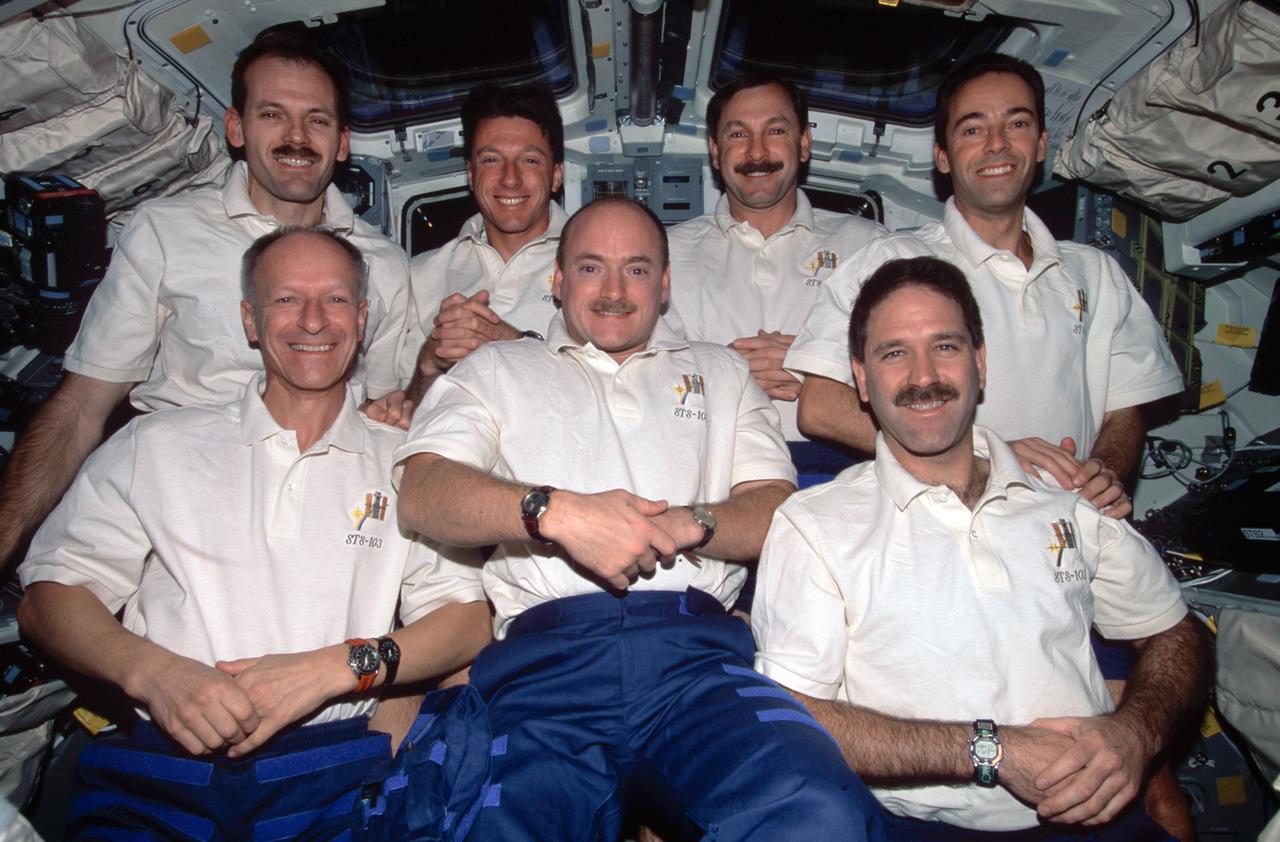 STS103-397-035 (19 - 27 December 1999) --- The seven astronauts aboard the Space Shuttle Discovery for NASA's third servicing visit to the Hubble Space Telescope (HST) pose for the traditional inflight crew portrait..In front are, from left, astronauts Claude Nicollier, Scott J. Kelly and John M. Grunsfeld.  Behind them are.astronauts Steven L. Smith, C. Michael Foale, Curtis L. Brown, Jr., and Jean-Francois Clervoy.  Nicollier and Clervoy are astronauts from the European Space Agency (ESA).