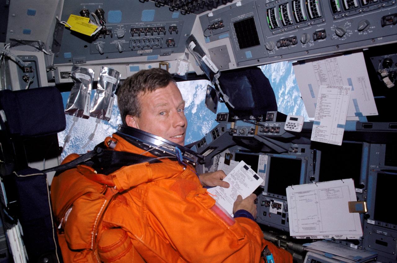 STS104-345-021 (25 July 2001) --- Attired in his shuttle launch and entry suit, astronaut Steven W. Lindsey, STS-104 commander, looks over a procedures checklist at the commander&#0146;s station on the forward flight deck of the space shuttle Atlantis.