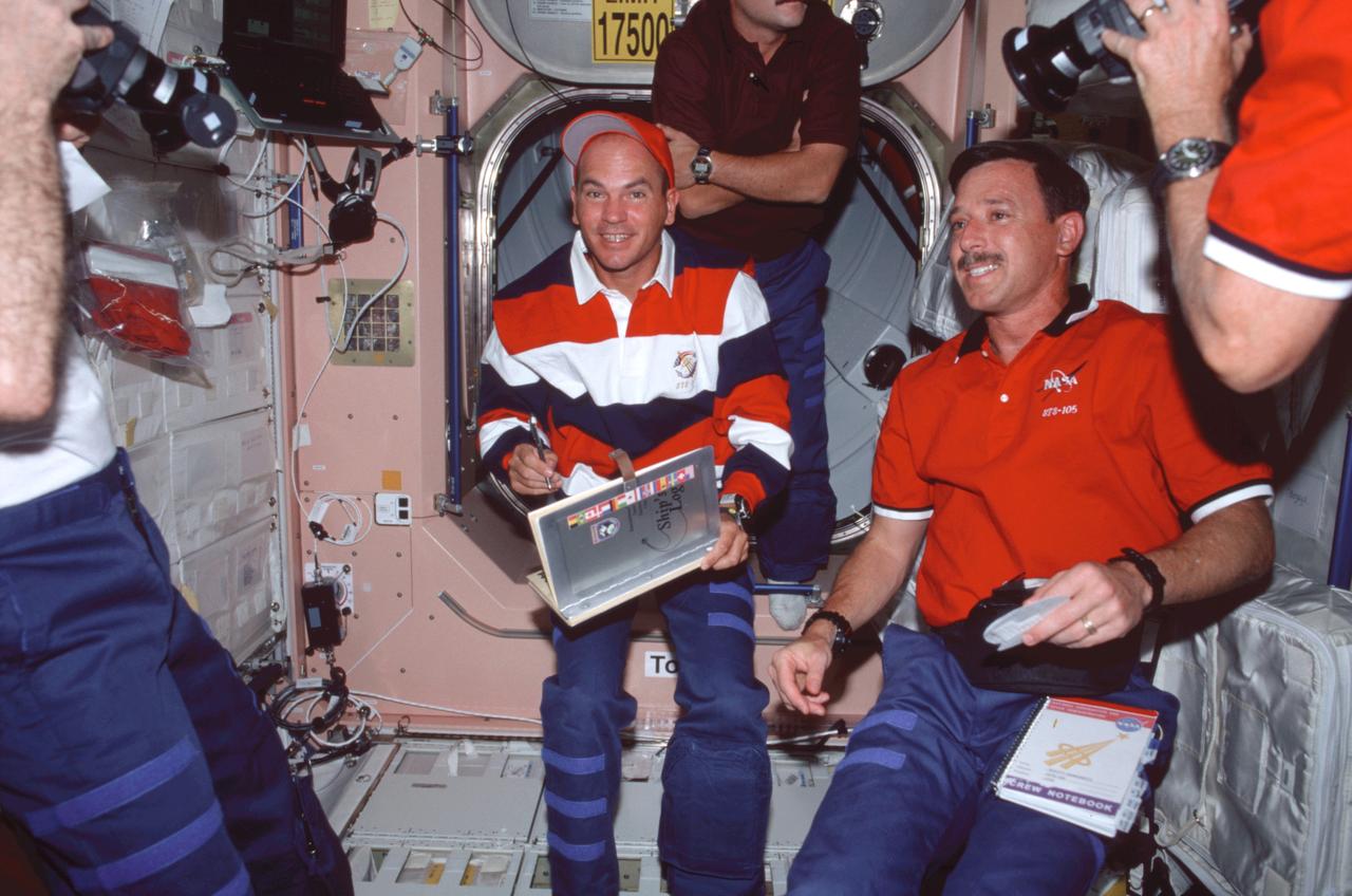 STS105-314-024 (10-22 August 2001) ---  Astronaut Frederick W. (Rick) Sturckow  (center), STS-105 pilot, is about to add his name to the log of visitors to the  International Space Station (ISS) during a brief break in the orbital outpost's Unity node. Astronaut Scott J. Horowitz, STS-105 mission commander, is at right.
