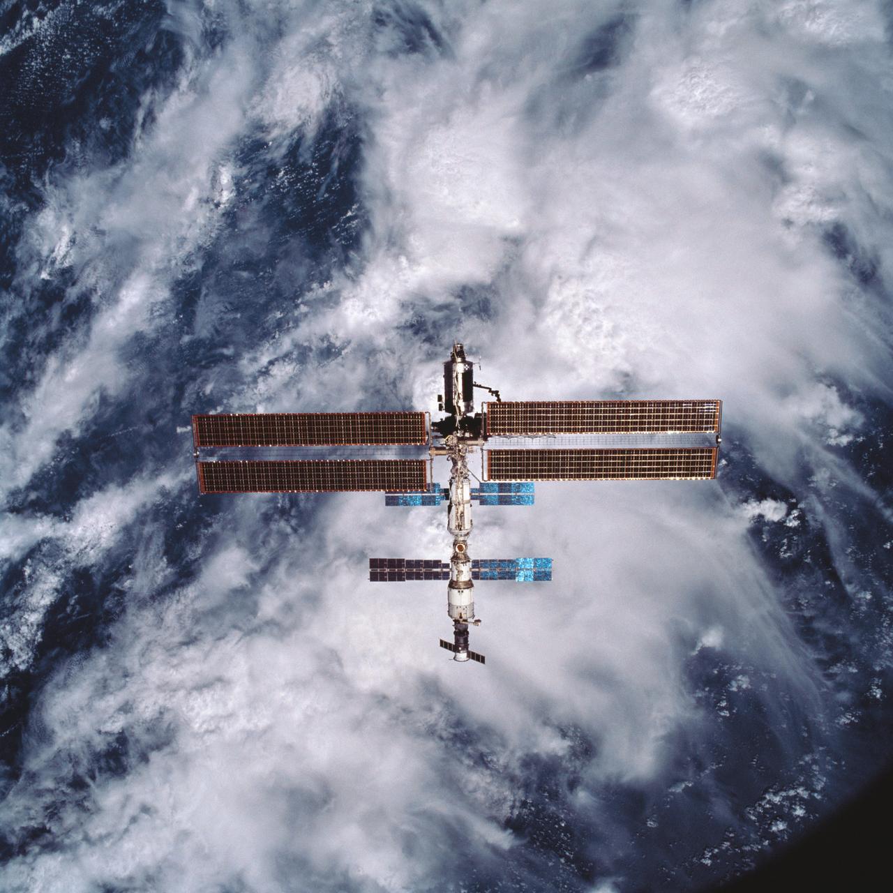 STS105-707-001 (20 August 2001) --- Backdropped against water and clouds, the International Space Station (ISS) is now separated from the Space Station Discovery after several days of joint activities and crew exchange. One of the astronauts aboard Discovery took this 70mm photograph from the aft flight deck.