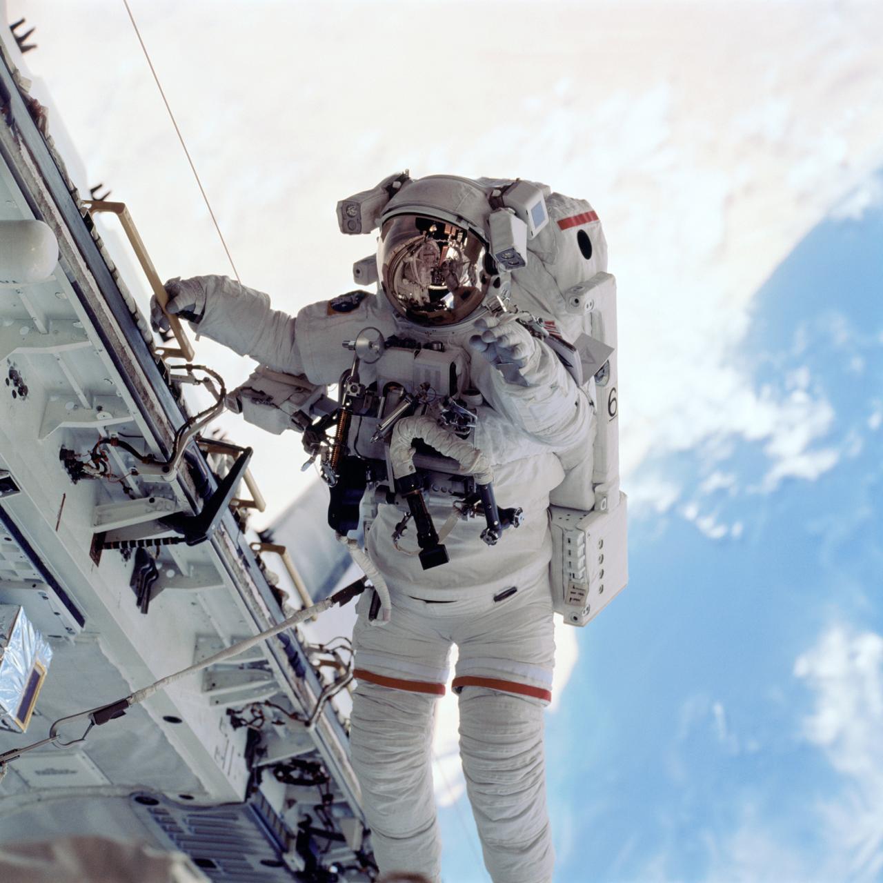 STS105-725-006 (16 August 2001) --- Astronaut Daniel T. Barry, STS-105 mission specialist, traverses along the Space Shuttle Discovery's payload bay, backdropped against the blue and white Earth, during one of two days of extravehicular activity (EVA). Barry was joined by astronaut Patrick G. Forrester, mission specialist, on both of the space walks scheduled for the STS-105 mission.