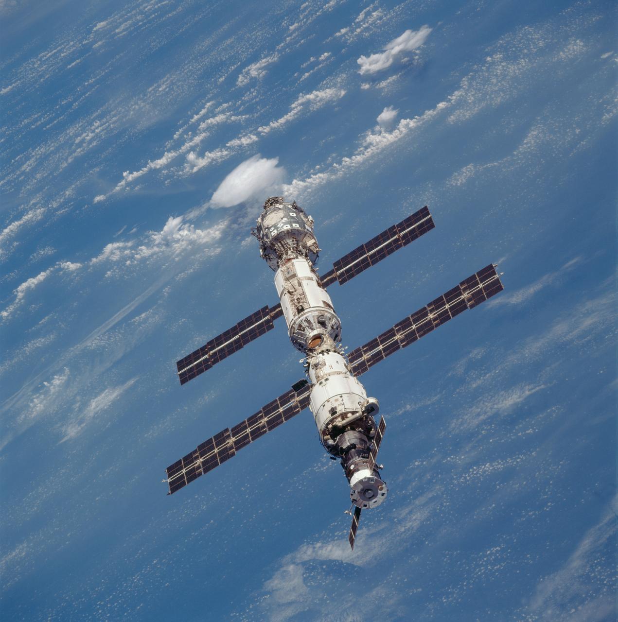 STS106-709-091 (8-20 September 2000) --- The International Space Station as photographed against clouds over a land mass on Earth during a fly-around by the Space Shuttle Atlantis.