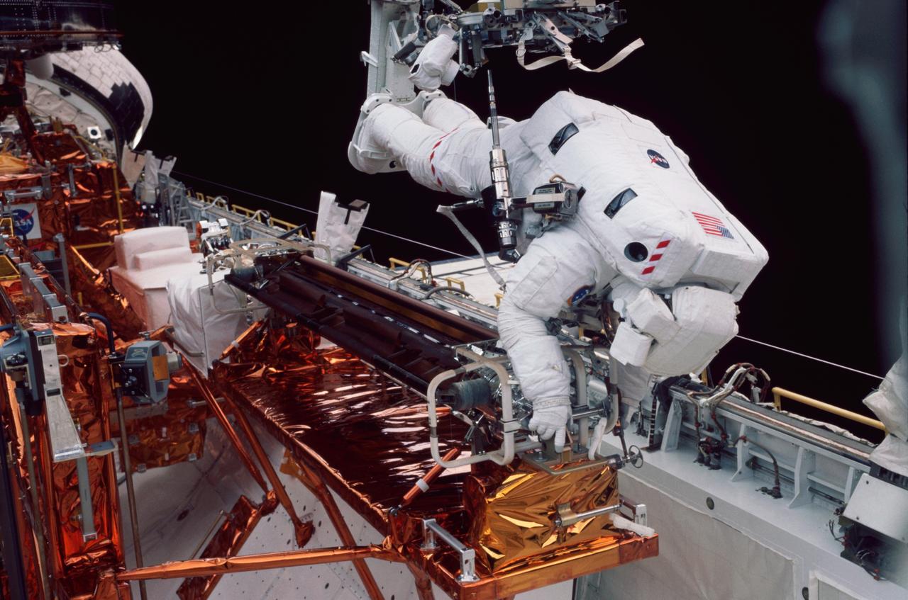 STS109-326-008 (5 March 2002) --- Astronaut Michael J. Massimino, mission specialist, works at the stowage area for the Hubble Space Telescope's   port side solar array. Astronauts    Massimino and James H. Newman removed the old port solar array and stowed it in Columbia&#0146;s payload bay for a return to Earth. They then went on to install a third-generation solar array and its associated electrical components. Two crew mates had accomplished the same feat with the starboard array on the previous day.