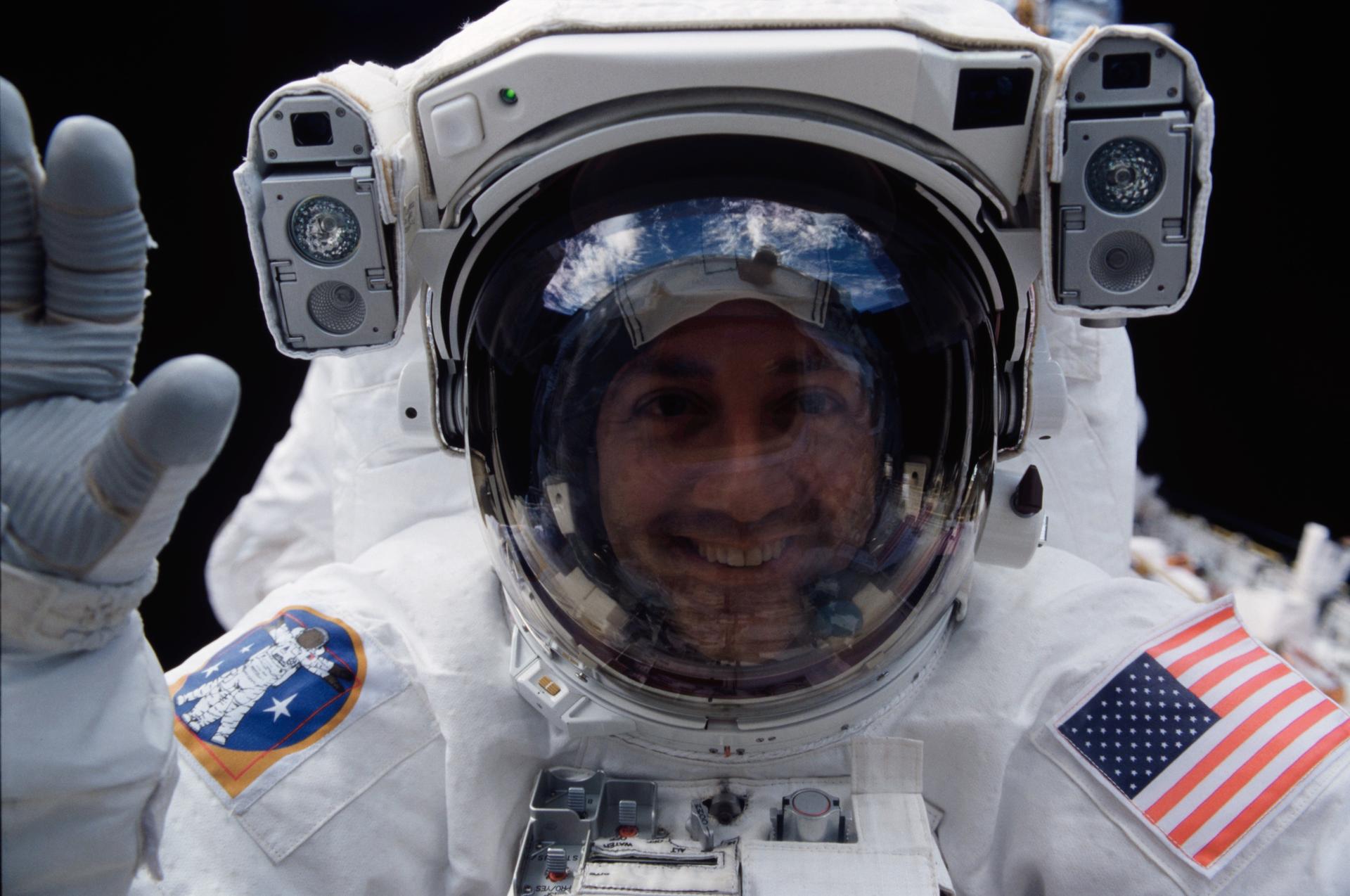 Astronaut Michael J. Massimino, STS-109 mission specialist, peers into Columbia's crew cabin during an EVA