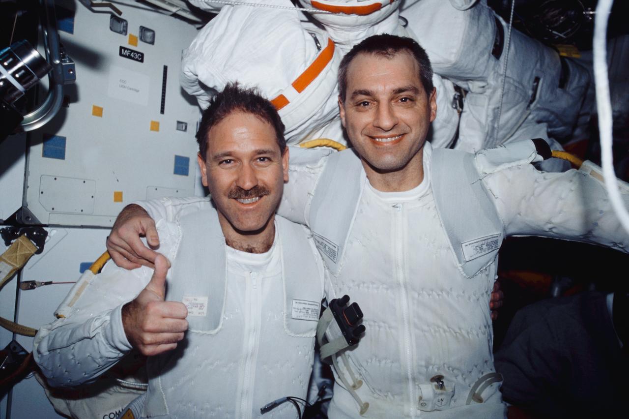 STS109-349-027 (4 March 2002) --- Astronauts John M. Grunsfeld and Richard M. Linnehan, STS-109 payload commander and mission specialist, respectively, wearing the liquid cooling and ventilation garment that complements the Extravehicular Mobility Unit (EMU) space suit, are photographed on the mid deck of the Space Shuttle Columbia after the mission&#0146;s first session of extravehicular activity (EVA). The EVA-1 team replaced one of the telescope&#0146;s two second-generation solar arrays, which is also known as SA2, and a Diode Box Assembly. The solar array was replaced with a new, third-generation solar array, which is called SA3. The space walkers also did some prep work for STS-109&#0146;s other space walks.