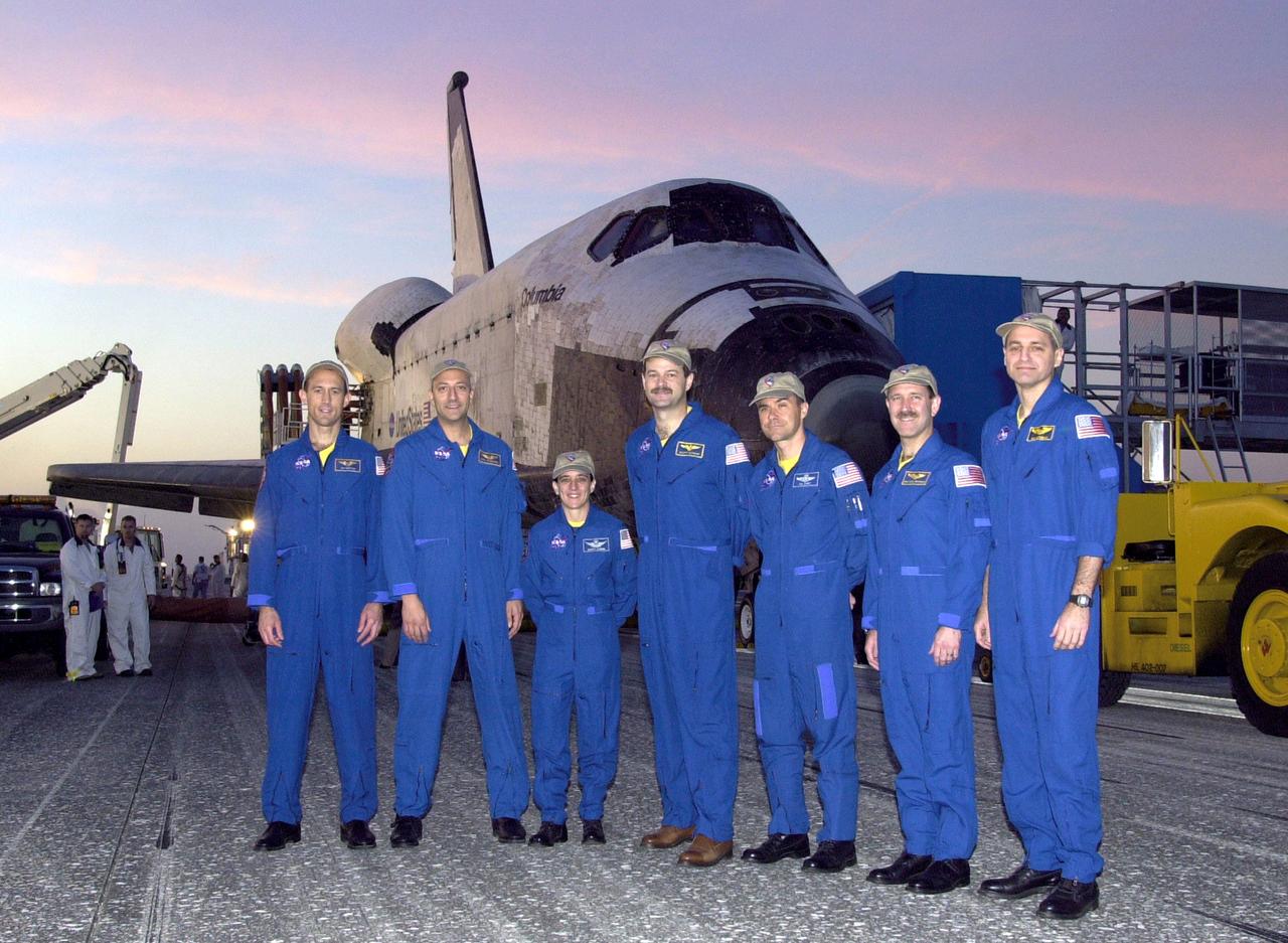 Posing in front of the Space Shuttle Columbia is the returning STS-109 crew. From left are astronauts James H. Newman, Michael J. Massimino, Nancy J. Currie, Scott D. Altman, Duane G. Carey, John M. Grunsfeld and Richard M. Linnehan. The crew returned to Earth after a successful 11-day mission servicing and upgrading the Hubble Space Telescope.