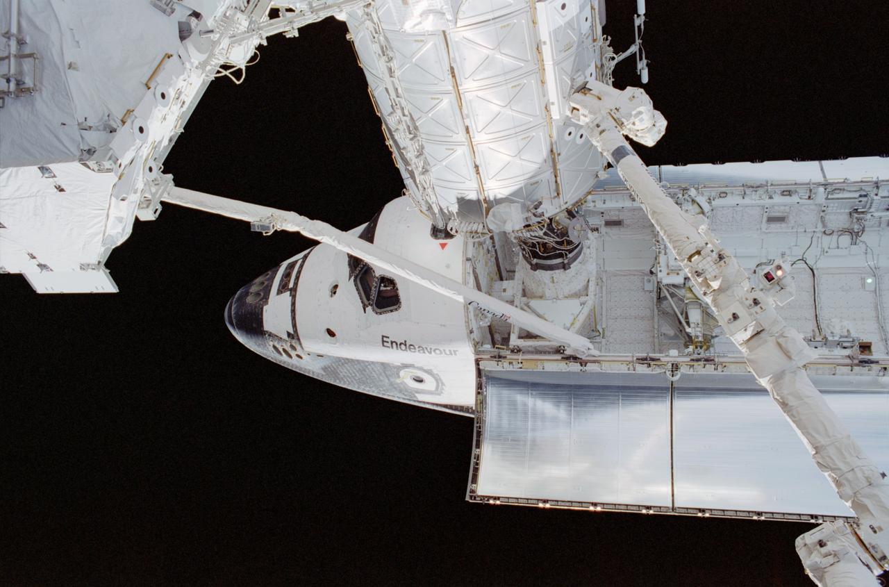 STS111-310-014 (9 June 2002) --- Backdropped by the blackness of space, the Space Shuttle Endeavour is pictured while docked to the Pressurized Mating Adapter (PMA-2) at the forward end of the Destiny laboratory on the International Space Station (ISS). A portion of the Canadarm2 is visible on the right and Endeavour&#0146;s robotic arm is in full view as it is stretched out with the S0 (S-zero) Truss at its end.