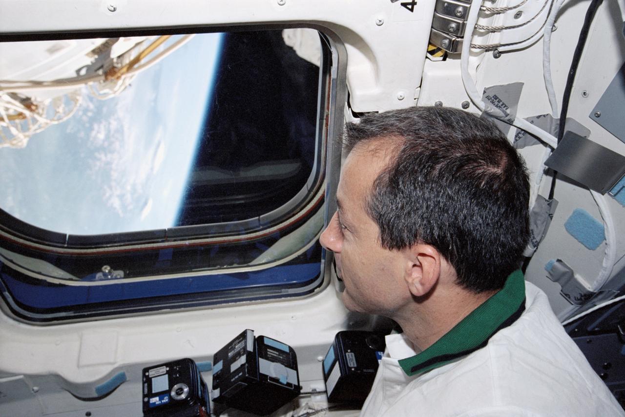 STS111-318-030 (5-19 June 2002) --- Astronaut Philippe Perrin, STS-111 mission specialist representing CNES, the French Space Agency, looks out an aft flight deck window of the Space Shuttle Endeavour.