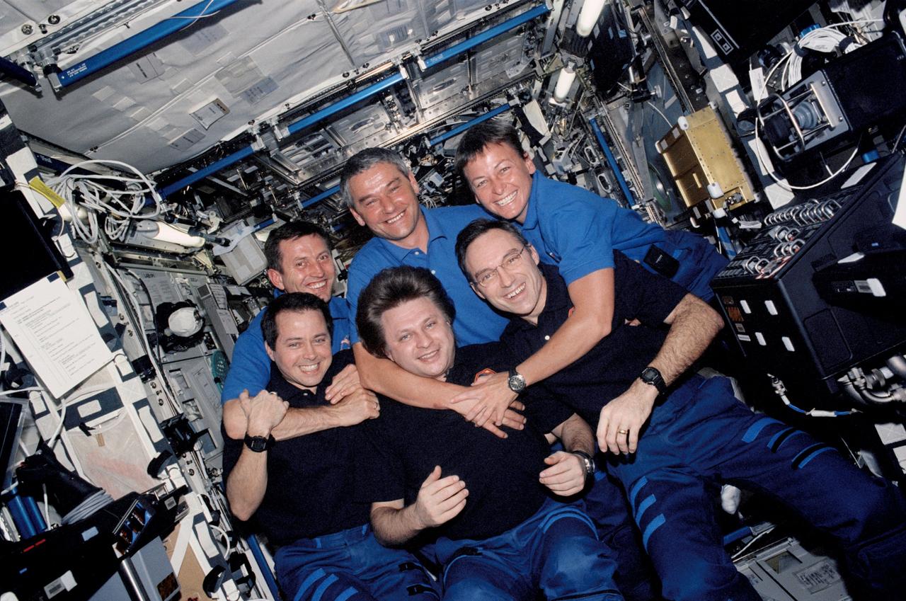 STS111-320-032 (5-19 June 2002) --- The Expedition Four (front row) and Expedition Five crewmembers gather for a group photo in the Destiny laboratory on the International Space Station (ISS). The Expedition Four crewmembers, from the left, are astronaut Daniel W. Bursch, flight engineer; cosmonaut Yury I. Onufrienko, mission commander; and astronaut Carl E. Walz, flight engineer. The Expedition Five crewmembers, from the left, are cosmonauts Sergei Y. Treschev, flight engineer; Valery G. Korzun, mission commander; and astronaut Peggy A. Whitson, flight engineer. Onufrienko, Korzun and Treschev represent Rosaviakosmos.