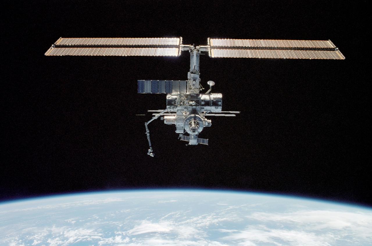 STS112-309-018 (9 October 2002) --- Backdropped by the blackness of space and Earth’s horizon, the International Space Station (ISS) was photographed by a crewmember aboard the Space Shuttle Atlantis during rendezvous and docking operations. Docking occurred at 10:17 a.m. (CDT) on October 9, 2002.