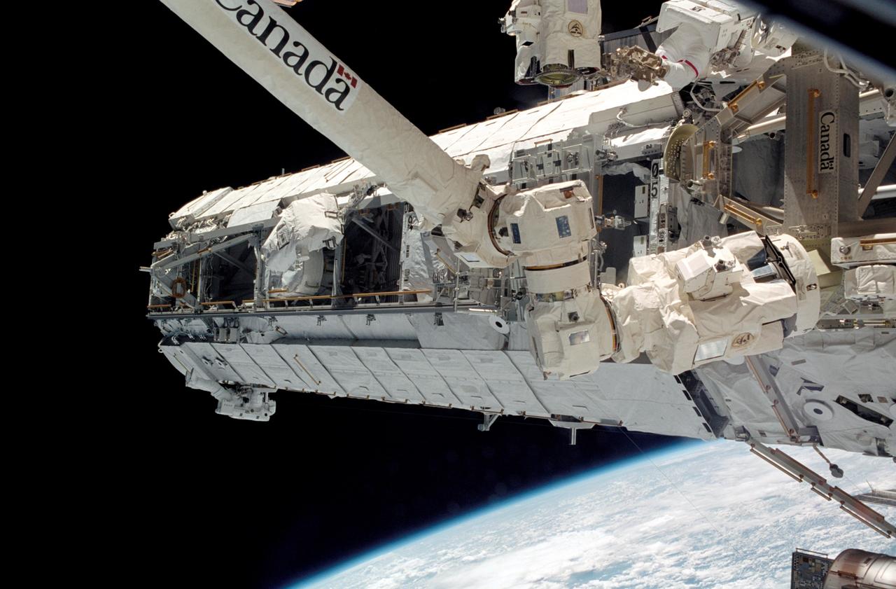 STS112-325-018 (10 October 2002) --- A view of the Starboard One (S1) Truss newly installed on the International Space Station (ISS) as photographed during the mission’s first scheduled session of extravehicular activity (EVA). The station’s Canadarm2 is in the foreground. Astronauts Piers J. Sellers (lower left) and David A. Wolf (upper right), both STS-112 mission specialists, are visible.