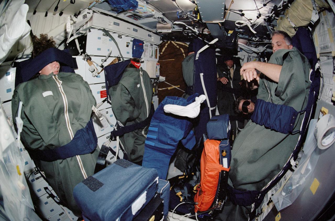STS112-345-028 (7-18 October 2002) --- The STS-112 crewmembers sleep on the middeck of the Space Shuttle Atlantis. Pictured are astronauts Sandra H. Magnus, David A. Wolf, Piers J. Sellers, mission specialists, and Jeffrey S. Ashby, mission commander.