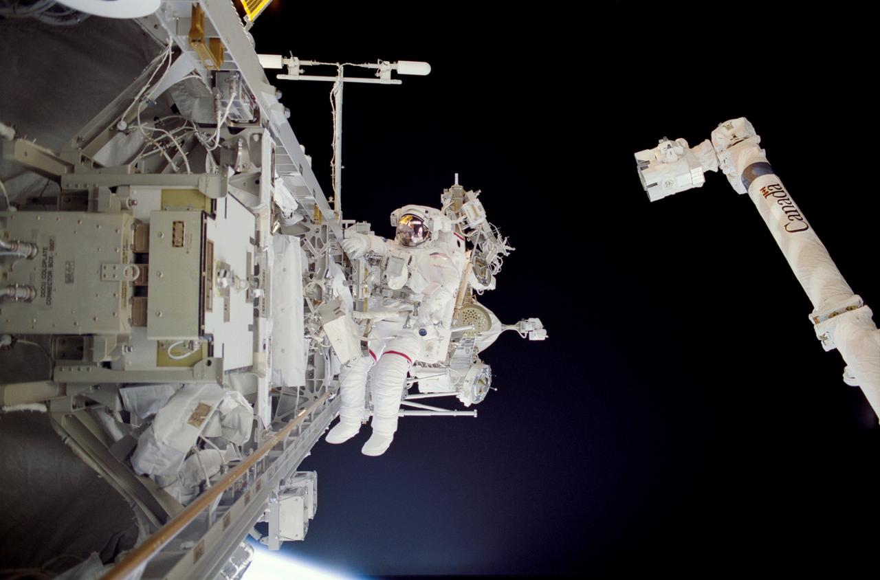STS113-307-009 (30 November 2002) --- Astronaut Michael E. Lopez-Alegria, STS-113 mission specialist, participates in the mission&#0146;s third spacewalk. The International Space Station&#0146;s (ISS) Canadarm2 is visible in right frame.
