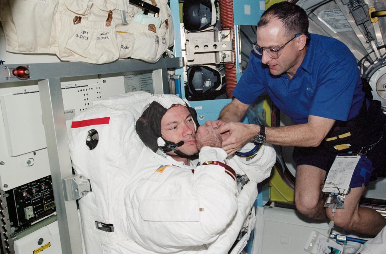 STS113-340-030 (28 November 2002) --- Astronaut Donald R. Pettit, Expedition Six NASA ISS science officer, assists astronaut Michael E. Lopez-Alegria, STS-113 mission specialist, with the final touches on his Extravehicular Mobility Unit (EMU) spacesuit in the Quest Airlock on the International Space Station (ISS). Lopez-Alegria is about to participate in the mission&#0146;s second scheduled session of extravehicular activity (EVA).