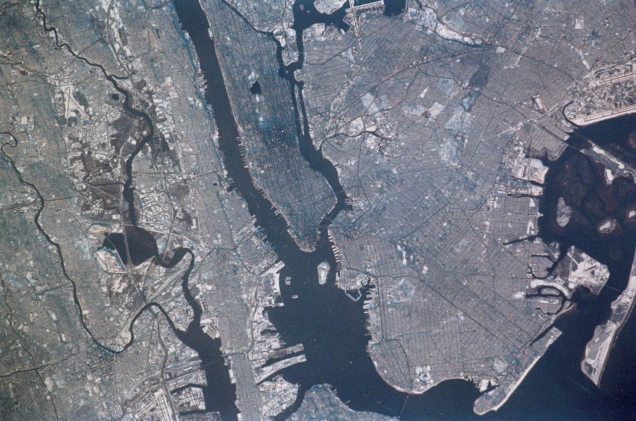 STS113-347-034 (23 November - 7 December 2002) --- The STS-113 crewmembers used a 35mm still camera to record this image of New York City. Manhattan Island appears just left of center, flanked by the lower Hudson River (left), and the East River (right). The lake in Central Park on Manhattan is particularly clear. The Verrazano Narrows Bridge appears center on the bottom margin of the view, dividing upper New York Bay from Lower New York Bay. Newark Bay is the body of water lower left. Three well known islands appear at the north (top) end of Upper New York Bay, the smallest being Liberty Island (with the Statue of Liberty not visible at this resolution), Ellis Island, the middle-sized island, and Governor's Island, the largest. Queens appears top right, and Brooklyn, lower right, with the Naval Air Station on Jamaica Bay on the right margin.