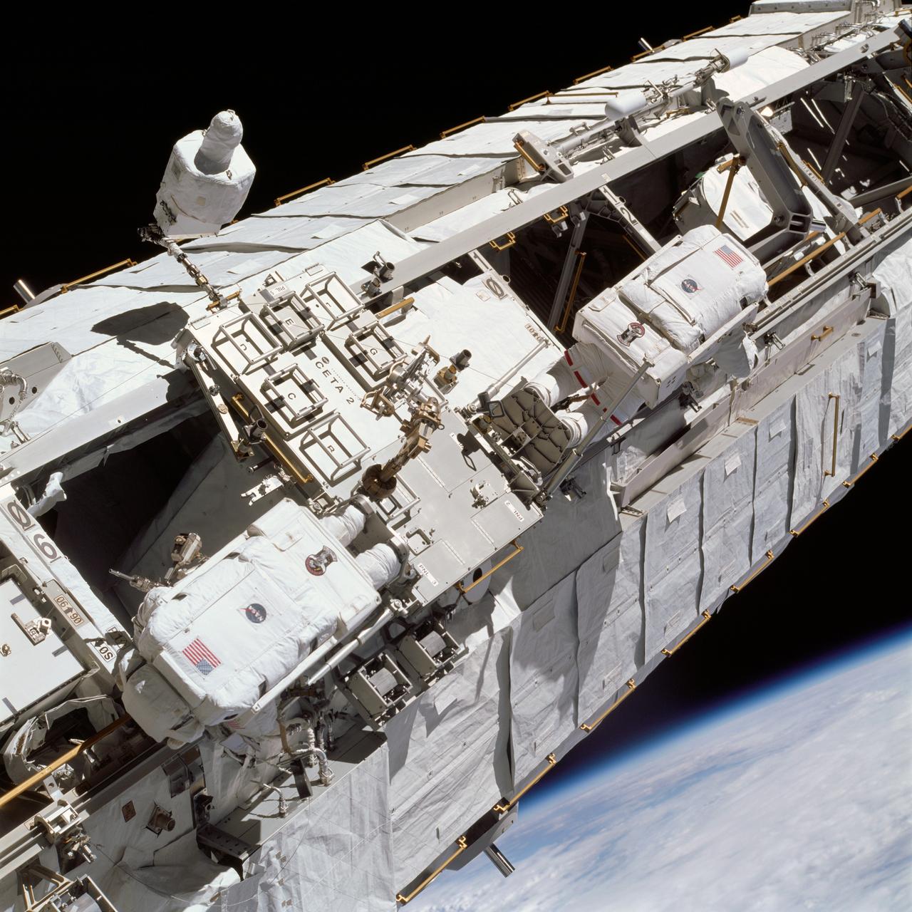 STS113-714-024 (26-30 November 2002) --- Astronauts Michael E. Lopez-Alegria (right) and John B. Herrington, STS-113 mission specialists, work near the Crew and Equipment Translation Aid (CETA) cart on a truss on the International Space Station (ISS) during a scheduled spacewalk for the mission.