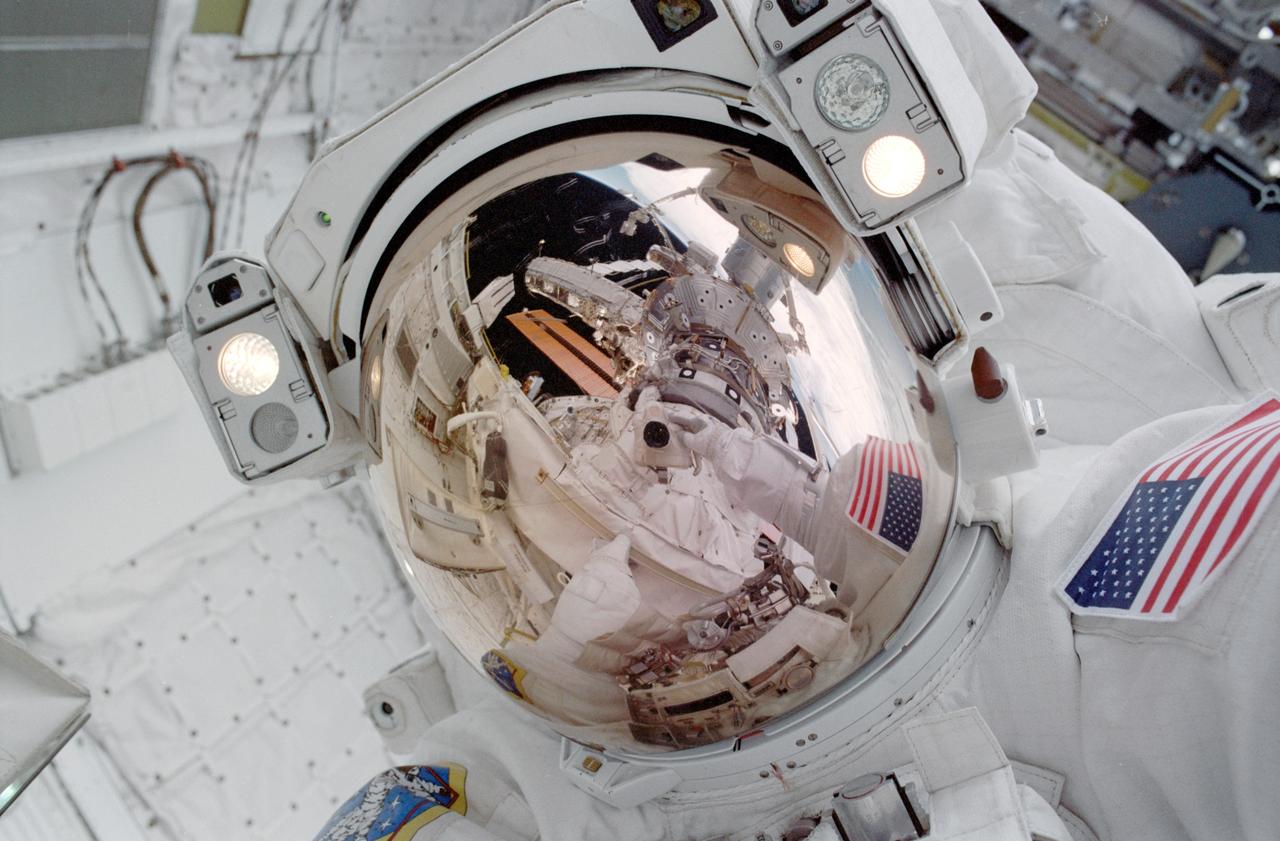 STS114-323-007 (30 July 2005) --- Astronaut Stephen K. Robinson, STS-114 mission specialist, used the pictured 35mm camera to expose a photo of his helmet visor during today;s session of extravehicular activity (EVA). A portion of the International Space Station is also visible in the reflection.
