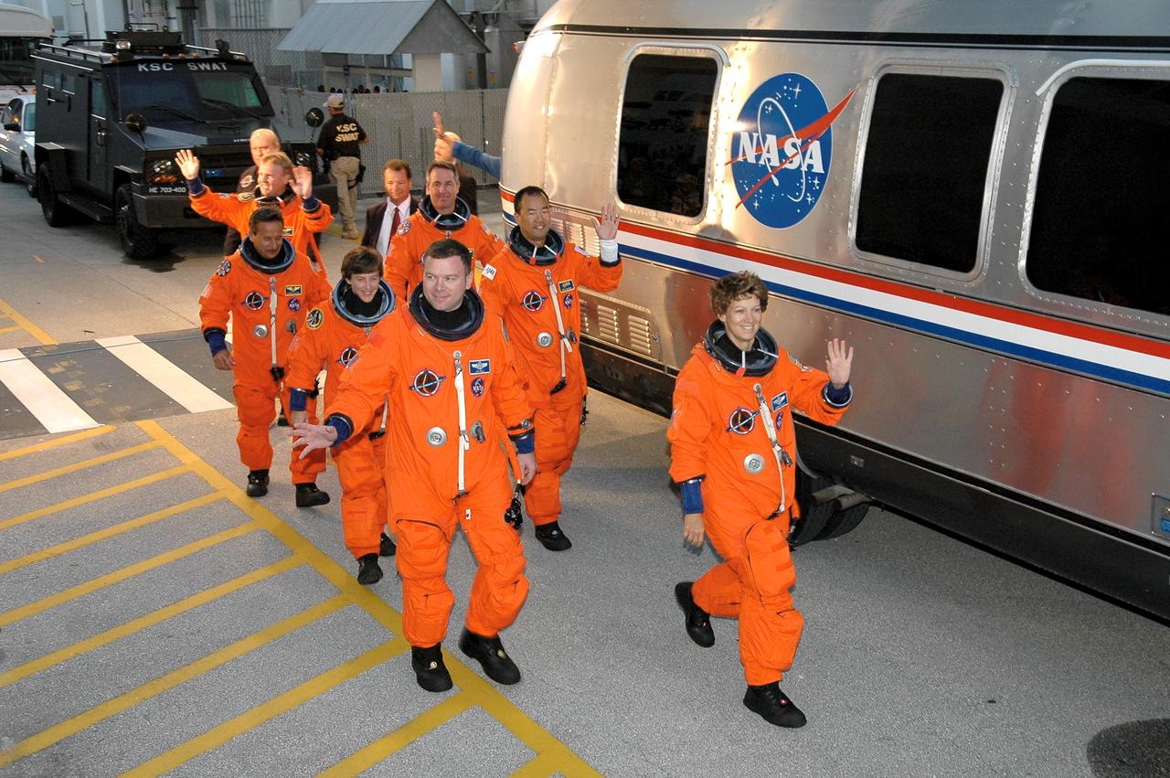 STS114-S-007 (26 July 2005) --- The STS-114 crew members, having donned their launch and entry suits, wave at KSC employees as they prepare to board the transfer van awaiting to take them to Launch Pad 39B. Eileen M. Collins, mission commander, leads the way. James M. Kelly, pilot, is at front left. Other crew members -- Wendy Lawrence, Andrew S.W. Thomas, Stephen K. Robinson, Charles J. Camarda and JAXA astronaut Soichi Noguchi -- follow.