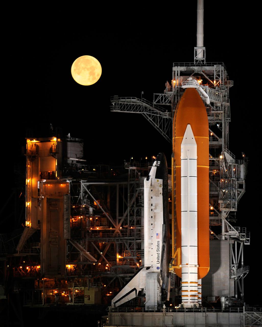 A nearly full Moon sets as the space shuttle Discovery sits atop Launch pad 39A at the Kennedy Space Center in Cape Canaveral, Florida, Wednesday, March 11, 2009. Photo Credit: (NASA/Bill Ingalls)