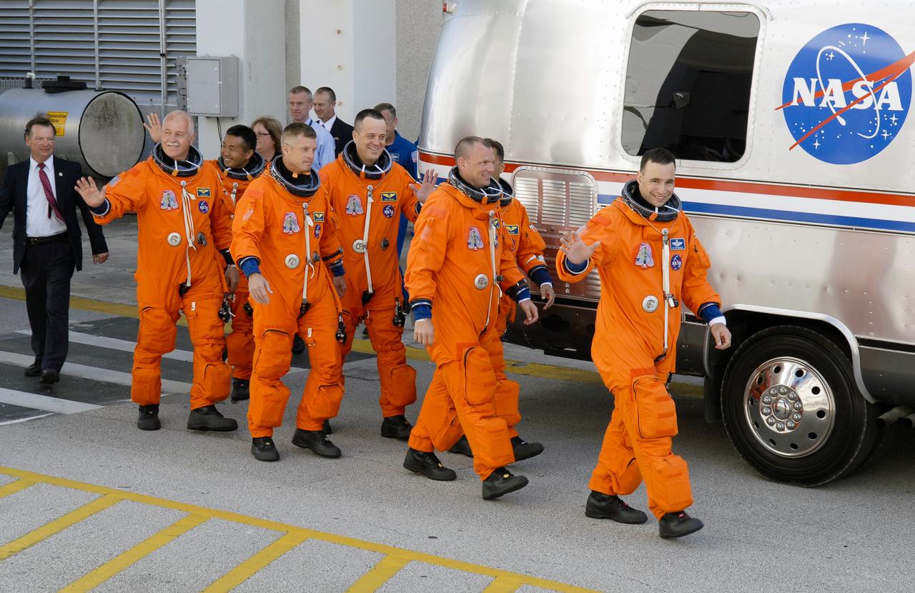 STS119-S-007 (15 March 2009) --- After suiting up, the STS-119 crewmembers exit the Operations and Checkout Building to board the Astrovan, which will take them to launch pad 39A for the launch of Space Shuttle Discovery on the STS-119 mission. From the left are astronauts John Phillips, Japan Aerospace Exploration Agency’s Koichi Wakata, Steve Swanson, Richard Arnold, all mission specialists; Tony Antonelli, pilot; Joseph Acaba (behind Antonelli), mission specialist; and Lee Archambault, commander. Wakata will join Expedition 18 in progress to serve as a flight engineer aboard the International Space Station. Discovery will deliver the final pair of power-generating solar array wings and the S6 truss segment. Installation of S6 will signal the station's readiness to house a six-member crew for conducting increased science.