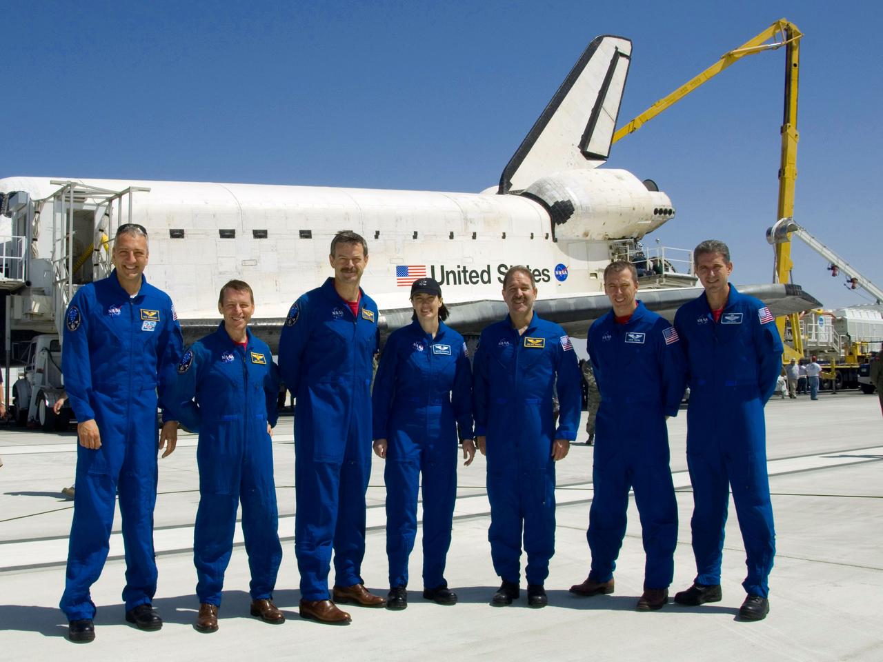 STS125-S-066 (24 May 2009) --- The STS-125 crew pose for a photo near Space Shuttle Atlantis on Runway 22 at Edwards Air Force Base in California following their landing which ended the STS-125 mission to repair and upgrade NASA?s Hubble Space Telescope. From the left are astronauts Mike Massimino, mission specialist; Gregory C. Johnson, pilot; Scott Altman, commander; Megan McArthur, John Grunsfeld, Andrew Feustel and Michael Good, all mission specialists. The main landing gear touched down at 8:39:05 a.m. (PDT) on May 24, 2009. Nose gear touchdown was at 8:39:15 a.m. Wheel-stop was at 8:40:15 a.m., bringing the mission?s elapsed time to 12 days, 21 hours, 37 minutes, 9 seconds. Landing opportunities on May 22, May 23 and May 24 were waved off due to weather concerns at NASA?s Kennedy Space Center in Florida, the shuttle?s primary landing site. Through five spacewalks, Hubble was refurbished and upgraded with state-of-the-art science instruments that will expand Hubble's capabilities and extend its operational lifespan through at least 2014.
