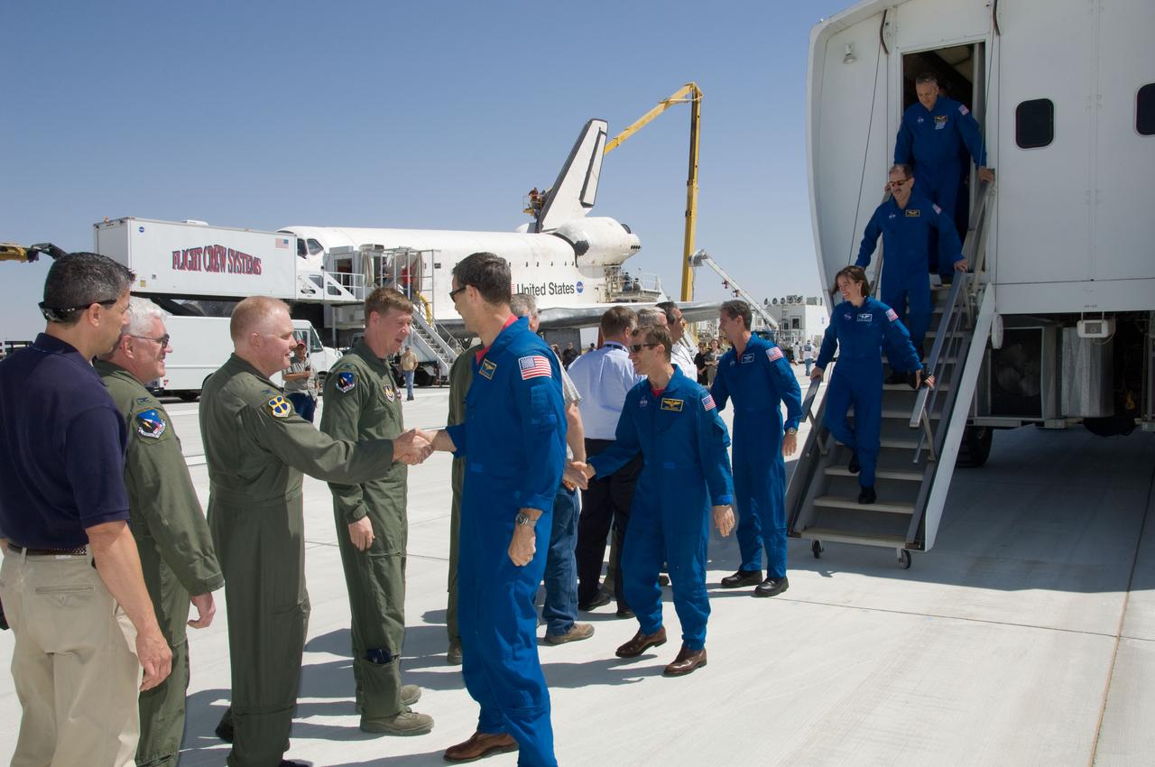 Personnel greet the STS-125 crew near Space Shuttle Atlantis on Runway 22 at Edwards Air Force Base in California following their landing which ended the STS-125 mission.  The main landing gear touched down at 8:39:05 a.m. (PDT) on May 24, 2009.  Nose gear touchdown was at 8:39:15 a.m.  Wheel-stop was at 8:40:15 a.m., bringing the mission's elapsed time to 12 days, 21 hours, 37 minutes, 9 seconds.  From the left are Commander (CDR) Scott Altman, Pilot (PLT) Gregory C. Johnson, Mission Specialist 1 (MS1) Michael Good, MS2 Megan McArthur, MS3 John Grunsfeld, and MS4 Mike Massimino.
