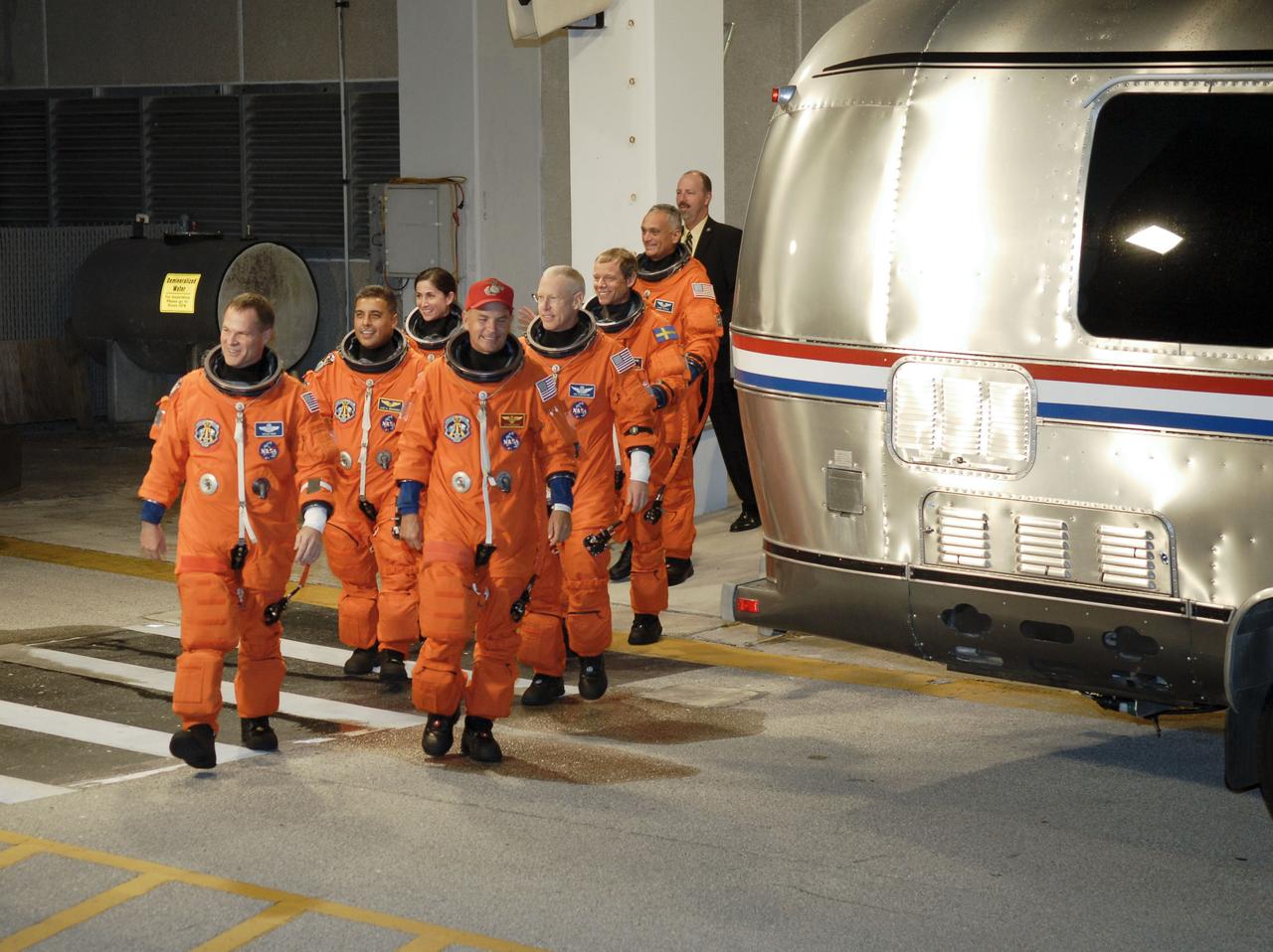 STS128-S-006 (28 Aug. 2009) --- After suiting up, the STS-128 crew members exit the Operations and Checkout Building to board the Astrovan, which will take them to launch pad 39A for the launch of Space Shuttle Discovery on the STS-128 mission. On the right (front to back) are astronauts Rick Sturckow, commander; Patrick Forrester, European Space Agency astronaut Christer Fuglesang and John ?Danny? Olivas, all mission specialists. On the left (front to back) are astronauts Kevin Ford, pilot; Jose Hernandez and Nicole Stott, both mission specialists. Stott will join Expedition 20 in progress to serve as a flight engineer aboard the International Space Station. The 13-day mission will deliver more than seven tons of supplies, science racks and equipment, as well as additional environmental hardware to sustain six crew members on the space station. The equipment includes a freezer to store research samples, a new sleeping compartment and the COLBERT treadmill. The mission is the 128th in the Space Shuttle Program, the 37th flight of Discovery and the 30th station assembly flight.
