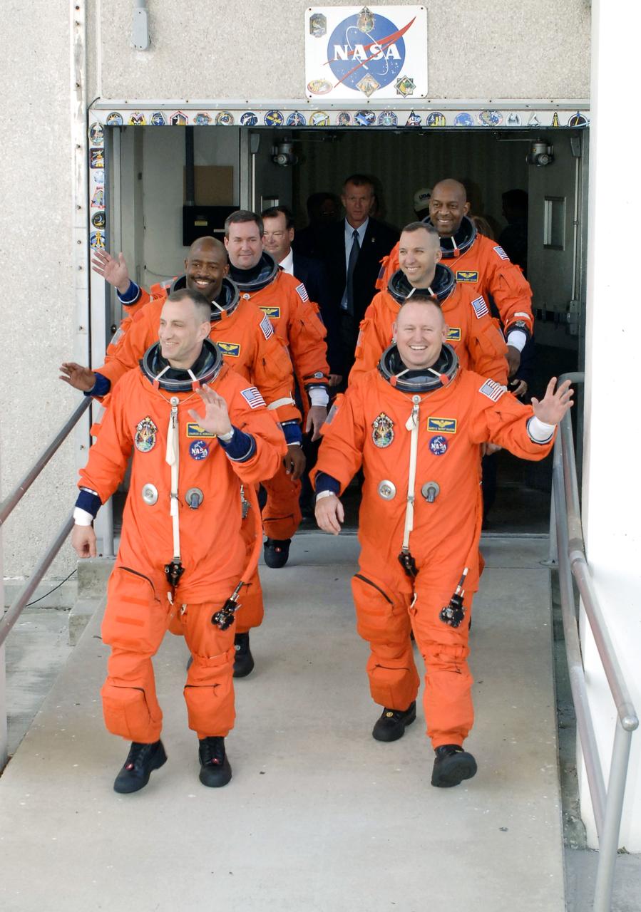 CAPE CANAVERAL, Fla. - At NASA's Kennedy Space Center in Florida, the astronauts on the STS-129 crew, dressed in their orange launch-and-entry suits, wave to spectators as they walk out of the Operations and Checkout Building for the 15-minute ride in the Astrovan to Launch Pad 39A. In the left column, from the front, are Commander Charles O. Hobaugh and Mission Specialists Leland Melvin and Mike Foreman. In the right column, from the front, are Pilot Barry E. Wilmore and Mission Specialists Randy Bresnik and Robert L. Satcher Jr. Liftoff is set for 2:28 p.m. EST Nov. 16. On STS-129, the crew will deliver two Express Logistics Carriers to the International Space Station, the largest of the shuttle's cargo carriers, containing 15 spare pieces of equipment including two gyroscopes, two nitrogen tank assemblies, two pump modules, an ammonia tank assembly and a spare latching end effector for the station's robotic arm. Atlantis will return to Earth a station crew member, Nicole Stott, who has spent more than two months aboard the orbiting laboratory. STS-129 is slated to be the final space shuttle Expedition crew rotation flight. For information on the STS-129 mission and crew, visit http://www.nasa.gov/mission_pages/shuttle/shuttlemissions/sts129/index.html. Photo credit: NASA/Kim Shiflett  