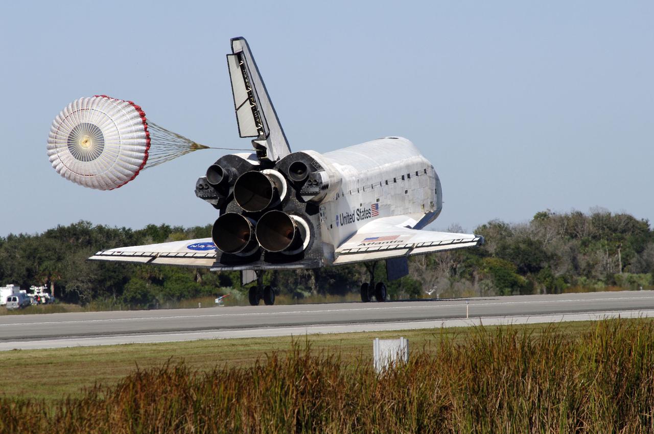 PHOTO CREDIT: NASA or National Aeronautics and Space Administration CAPE CANAVERAL, Fla. - With drag chute unfurled, space shuttle Atlantis lands on Runway 33 at the Shuttle Landing Facility at NASA's Kennedy Space Center in Florida after 11 days in space, completing the 4.5-million mile STS-129 mission on orbit 171. Main gear touchdown was at 9:44:23 a.m. EDT. Nose gear touchdown was at 9:44:36 a.m., and wheels stop was at 9:45:05 a.m. Aboard Atlantis are Commander Charles O. Hobaugh; Pilot Barry E. Wilmore; Mission Specialists Leland Melvin, Randy Bresnik, Mike Foreman and Robert L. Satcher Jr.; and Expedition 20 and 21 Flight Engineer Nicole Stott who spent 87 days aboard the International Space Station. STS-129 is the final space shuttle Expedition crew rotation flight on the manifest. On STS-129, the crew delivered 14 tons of cargo to the orbiting laboratory, including two ExPRESS Logistics Carriers containing spare parts to sustain station operations after the shuttles are retired next year. For information on the STS-129 mission and crew, visit http://www.nasa.gov/mission_pages/shuttle/shuttlemissions/sts129/index.html. Photo credit: NASA/Kim Shiflett