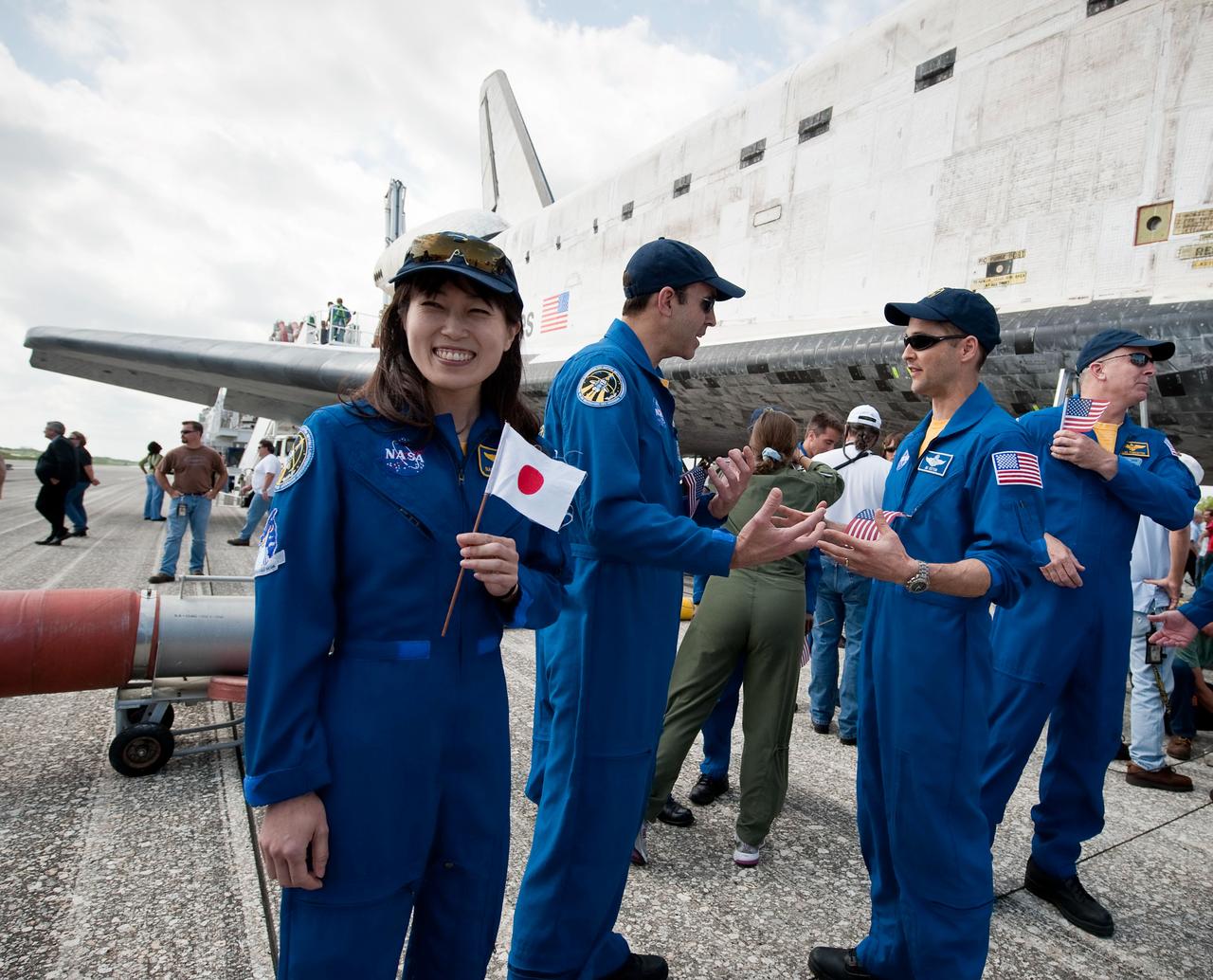 STS131-S-093 (20 April 2010) --- Japanese astronaut Naoko Yamazaki, holds a Japanese flag near the space shuttle Discovery shortly after Discovery and the STS-131 crew landed at the Kennedy Space Center in Cape Canaveral, Fla., on April 20, 2010. NASA astronauts Alan Poindexter, commander; James P. Dutton Jr., pilot; Dorothy Metcalf-Lindenburger, Rick Mastracchio, Stephanie Wilson, Clayton Anderson and Japanese astronaut Naoko Yamazaki, all mission specialists, returned from their 15-day journey of more than 6.2 million miles. The STS-131 mission to the International Space Station delivered science racks, new crew sleeping quarters, equipment and supplies. Photo credit: NASA/Bill Ingalls