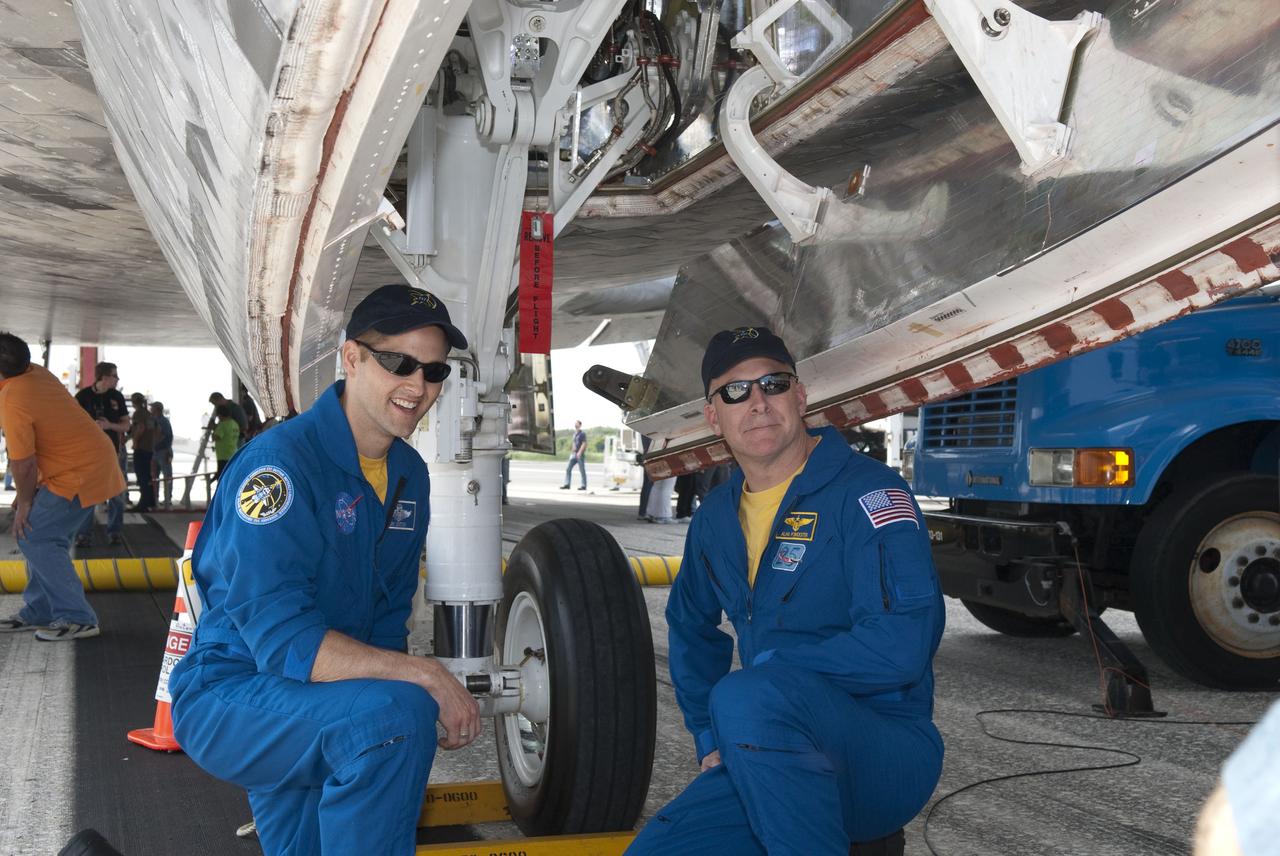 STS131-S-145 (20 April 2010) --- At the Shuttle Landing Facility at NASA's Kennedy Space Center in Florida, NASA astronauts Alan Poindexter (right) and James P. Dutton Jr., STS-131 commander and pilot, respectively, pose for a photo under space shuttle Discovery. Discovery landed on Runway 33 after 15 days in space, completing the more than 6.2-million-mile STS-131 mission on orbit 238. Main gear touchdown was at 9:08:35 a.m. (EDT) on April 20, 2010, followed by nose gear touchdown at 9:08:47 a.m. and wheelstop at 9:09:33 a.m. The seven-member STS-131 crew carried the Leonardo Multi-Purpose Logistics Module, filled with supplies, a new crew sleeping quarters and science racks that were transferred to the International Space Station's laboratories. The crew also switched out a gyroscope on the station?s truss, installed a spare ammonia storage tank and retrieved a Japanese experiment from the station?s exterior. STS-131 is the 33rd shuttle mission to the station and the 131st shuttle mission overall.