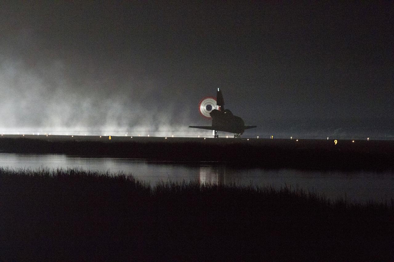 STS134-S-072 (1 June 2011) --- Xenon lights illuminate space shuttle Endeavour's unfurled drag chute as the vehicle rolls to a stop on the Shuttle Landing Facility's Runway 15 at NASA's Kennedy Space Center in Florida for the final time. Main gear touchdown was at 2:34:51 a.m. (EDT) on June 1, 2011, followed by nose gear touchdown at 2:35:04 a.m., and wheelstop at 2:35:36 a.m. Onboard are NASA astronauts Mark Kelly, STS-134 commander; Greg H. Johnson, pilot; Michael Fincke, Andrew Feustel, Greg Chamitoff and European Space Agency astronaut Roberto Vittori, all mission specialists. STS-134 delivered the Alpha Magnetic Spectrometer-2 (AMS) and the Express Logistics Carrier-3 (ELC-3) to the International Space Station. AMS will help researchers understand the origin of the universe and search for evidence of dark matter, strange matter and antimatter from the station. ELC-3 carried spare parts that will sustain station operations once the shuttles are retired from service. STS-134 was the 25th and final flight for Endeavour, which has spent 299 days in space, orbited Earth 4,671 times and traveled 122,883,151 miles. Photo credit: NASA