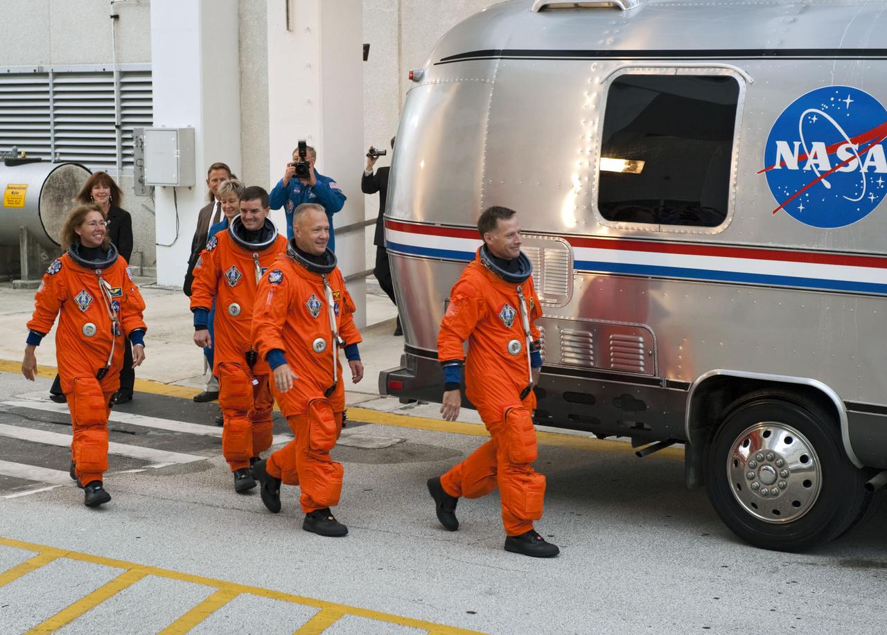 STS135-S-024 (8 July 2011) --- After suiting up, the STS-135 crew members exit the Operations and Checkout Building to board the Astrovan, which will take them to launch pad 39A for the launch of space shuttle Atlantis on the STS-135 mission. From the right are NASA astronauts Chris Ferguson, commander; Doug Hurley, pilot; Rex Walheim and Sandy Magnus, both mission specialists. Atlantis is scheduled to lift off at 11:26 a.m. (EDT) on July 8 for its mission to the International Space Station. STS-135 will deliver the Raffaello multi-purpose logistics module packed with supplies and spare parts for the orbiting outpost. Atlantis also will fly the Robotic Refueling Mission experiment that will investigate the potential for robotically refueling existing satellites in orbit. In addition, Atlantis will return with a failed ammonia pump module to help NASA better understand the failure mechanism and improve pump designs for future systems. STS-135 will be the 33rd flight of Atlantis, the 37th shuttle mission to the space station, and the 135th and final mission of NASA's Space Shuttle Program. Photo credit: NASA