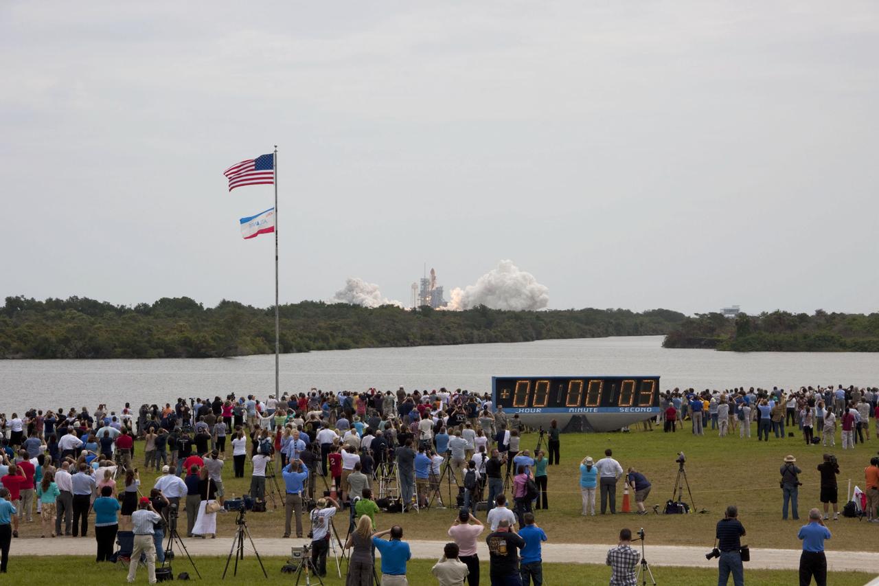 STS135-S-035 (8 July 2011) --- Members of the media and employees gather near the countdown clock to see the launch of space shuttle Atlantis as it lifts off Launch Pad 39A at NASA's Kennedy Space Center in Florida at 11:29 a.m. (EDT) on July 8, 2011. Onboard are NASA astronauts Chris Ferguson, STS-135 commander; Doug Hurley, pilot; Sandy Magnus and Rex Walheim, both mission specialists. STS-135 will deliver the Raffaello multi-purpose logistics module packed with supplies and spare parts for the International Space Station. Atlantis also will fly the Robotic Refueling Mission experiment that will investigate the potential for robotically refueling existing satellites in orbit. In addition, Atlantis will return with a failed ammonia pump module to help NASA better understand the failure mechanism and improve pump designs for future systems. STS-135 will be the 33rd flight of Atlantis, the 37th shuttle mission to the space station, and the 135th and final mission of NASA's Space Shuttle Program. Photo credit: NASA
