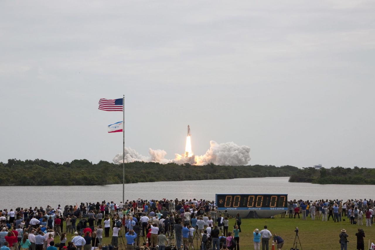 STS135-S-036 (8 July 2011) --- Members of the media and employees gather near the countdown clock to see the launch of space shuttle Atlantis as it lifts off Launch Pad 39A at NASA's Kennedy Space Center in Florida at 11:29 a.m. (EDT) on July 8, 2011. Onboard are NASA astronauts Chris Ferguson, STS-135 commander; Doug Hurley, pilot; Sandy Magnus and Rex Walheim, both mission specialists. STS-135 will deliver the Raffaello multi-purpose logistics module packed with supplies and spare parts for the International Space Station. Atlantis also will fly the Robotic Refueling Mission experiment that will investigate the potential for robotically refueling existing satellites in orbit. In addition, Atlantis will return with a failed ammonia pump module to help NASA better understand the failure mechanism and improve pump designs for future systems. STS-135 will be the 33rd flight of Atlantis, the 37th shuttle mission to the space station, and the 135th and final mission of NASA's Space Shuttle Program. Photo credit: NASA