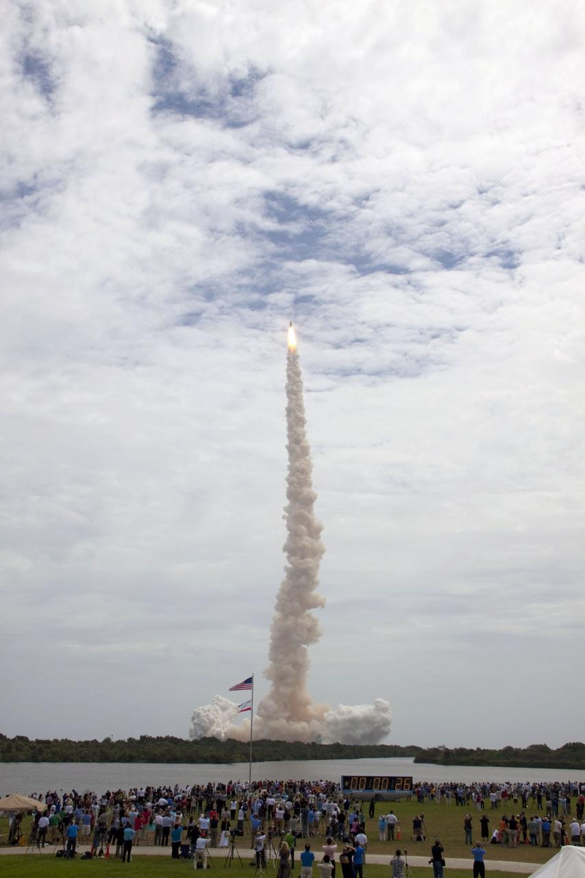 STS135-S-038 (8 July 2011) --- Members of the media and employees gather near the countdown clock to see the launch of space shuttle Atlantis as it lifts off Launch Pad 39A at NASA's Kennedy Space Center in Florida at 11:29 a.m. (EDT) on July 8, 2011. Onboard are NASA astronauts Chris Ferguson, STS-135 commander; Doug Hurley, pilot; Sandy Magnus and Rex Walheim, both mission specialists. STS-135 will deliver the Raffaello multi-purpose logistics module packed with supplies and spare parts for the International Space Station. Atlantis also will fly the Robotic Refueling Mission experiment that will investigate the potential for robotically refueling existing satellites in orbit. In addition, Atlantis will return with a failed ammonia pump module to help NASA better understand the failure mechanism and improve pump designs for future systems. STS-135 will be the 33rd flight of Atlantis, the 37th shuttle mission to the space station, and the 135th and final mission of NASA's Space Shuttle Program. Photo credit: NASA