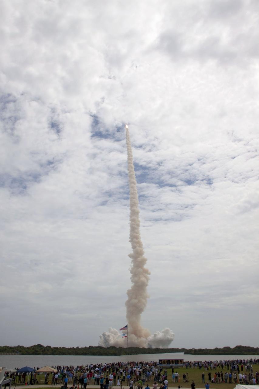 STS135-S-039 (8 July 2011) --- Members of the media and employees gather near the countdown clock to see the launch of space shuttle Atlantis as it lifts off Launch Pad 39A at NASA's Kennedy Space Center in Florida at 11:29 a.m. (EDT) on July 8, 2011. Onboard are NASA astronauts Chris Ferguson, STS-135 commander; Doug Hurley, pilot; Sandy Magnus and Rex Walheim, both mission specialists. STS-135 will deliver the Raffaello multi-purpose logistics module packed with supplies and spare parts for the International Space Station. Atlantis also will fly the Robotic Refueling Mission experiment that will investigate the potential for robotically refueling existing satellites in orbit. In addition, Atlantis will return with a failed ammonia pump module to help NASA better understand the failure mechanism and improve pump designs for future systems. STS-135 will be the 33rd flight of Atlantis, the 37th shuttle mission to the space station, and the 135th and final mission of NASA's Space Shuttle Program. Photo credit: NASA