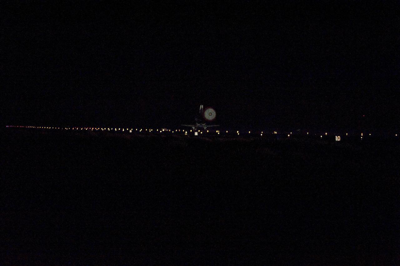 STS135-S-221 (21 July 2011) --- Space shuttle Atlantis' drag chute is illuminated as the spacecraft glides to a stop on Runway 15 at NASA's Kennedy Space Center in Florida for the last time. Securing the space shuttle fleet's place in history, Atlantis marked the 26th nighttime landing of NASA's Space Shuttle Program and the 78th landing at Kennedy. Main gear touchdown was at 5:57:00 a.m. (EDT) on July 21, 2011, followed by nose gear touchdown at 5:57:20 a.m., and wheelstop at 5:57:54 a.m. Onboard are NASA astronauts Chris Ferguson, STS-135 commander; Doug Hurley, pilot; Sandy Magnus and Rex Walheim, both mission specialists. On the 37th shuttle mission to the International Space Station, STS-135 delivered more than 9,400 pounds of spare parts, equipment and supplies in the Raffaello multi-purpose logistics module that will sustain station operations for the next year. STS-135 was the 33rd and final flight for Atlantis, which has spent 307 days in space, orbited Earth 4,848 times and traveled 125,935,769 miles. Photo credit: NASA