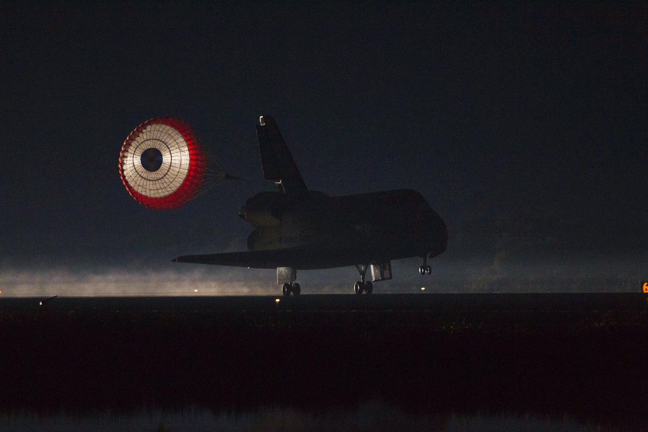 STS135-S-254 (21 July 2011) --- Space shuttle Atlantis' drag chute slows the shuttle as it lands on Runway 15 at the Shuttle Landing Facility at NASA's Kennedy Space Center in Florida. Securing the space shuttle fleet's place in history, Atlantis marked the 26th nighttime landing of NASA's Space Shuttle Program and the 78th landing at Kennedy. Main gear touchdown was at 5:57:00 a.m. (EDT) on July 21, 2011, followed by nose gear touchdown at 5:57:20 a.m., and wheelstop at 5:57:54 a.m. Onboard are NASA astronauts Chris Ferguson, STS-135 commander; Doug Hurley, pilot; Sandy Magnus and Rex Walheim, both mission specialists. On the 37th shuttle mission to the International Space Station, STS-135 delivered more than 9,400 pounds of spare parts, equipment and supplies in the Raffaello multi-purpose logistics module that will sustain station operations for the next year. STS-135 was the 33rd and final flight for Atlantis, which has spent 307 days in space, orbited Earth 4,848 times and traveled 125,935,769 miles. Photo credit: NASA