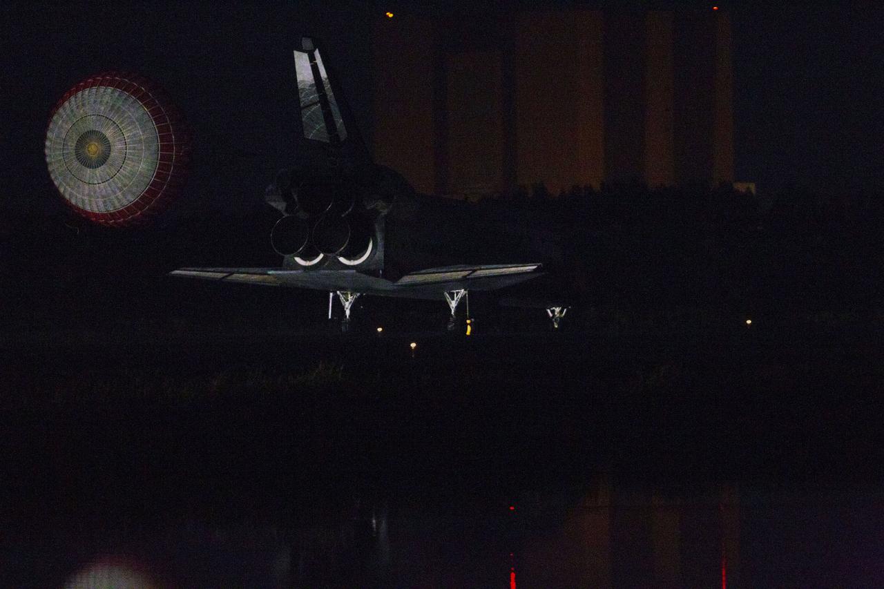 STS135-S-255 (21 July 2011) --- Space shuttle Atlantis' drag chute slows the shuttle as it lands on Runway 15 at the Shuttle Landing Facility at NASA's Kennedy Space Center in Florida. Securing the space shuttle fleet's place in history, Atlantis marked the 26th nighttime landing of NASA's Space Shuttle Program and the 78th landing at Kennedy. Main gear touchdown was at 5:57:00 a.m. (EDT) on July 21, 2011, followed by nose gear touchdown at 5:57:20 a.m., and wheelstop at 5:57:54 a.m. Onboard are NASA astronauts Chris Ferguson, STS-135 commander; Doug Hurley, pilot; Sandy Magnus and Rex Walheim, both mission specialists. On the 37th shuttle mission to the International Space Station, STS-135 delivered more than 9,400 pounds of spare parts, equipment and supplies in the Raffaello multi-purpose logistics module that will sustain station operations for the next year. STS-135 was the 33rd and final flight for Atlantis, which has spent 307 days in space, orbited Earth 4,848 times and traveled 125,935,769 miles. Photo credit: NASA