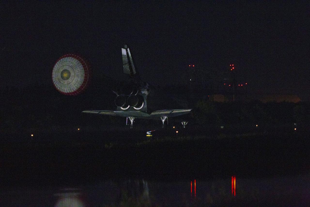 STS135-S-257 (21 July 2011) --- Space shuttle Atlantis' drag chute slows the shuttle as it lands on Runway 15 at the Shuttle Landing Facility at NASA's Kennedy Space Center in Florida. Securing the space shuttle fleet's place in history, Atlantis marked the 26th nighttime landing of NASA's Space Shuttle Program and the 78th landing at Kennedy. Main gear touchdown was at 5:57:00 a.m. (EDT) on July 21, 2011, followed by nose gear touchdown at 5:57:20 a.m., and wheelstop at 5:57:54 a.m. Onboard are NASA astronauts Chris Ferguson, STS-135 commander; Doug Hurley, pilot; Sandy Magnus and Rex Walheim, both mission specialists. On the 37th shuttle mission to the International Space Station, STS-135 delivered more than 9,400 pounds of spare parts, equipment and supplies in the Raffaello multi-purpose logistics module that will sustain station operations for the next year. STS-135 was the 33rd and final flight for Atlantis, which has spent 307 days in space, orbited Earth 4,848 times and traveled 125,935,769 miles. Photo credit: NASA