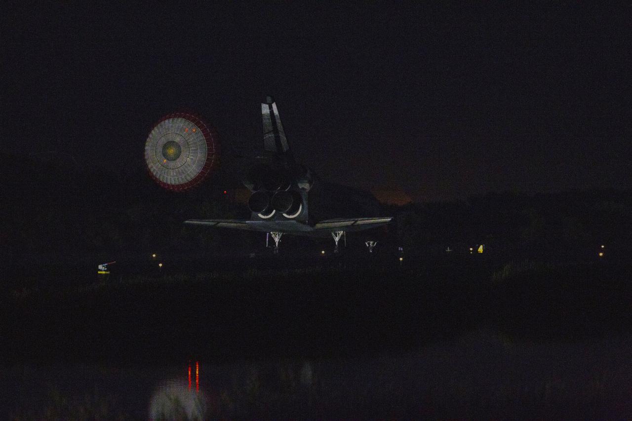 STS135-S-259 (21 July 2011) --- Space shuttle Atlantis' drag chute slows the shuttle as it lands on Runway 15 at the Shuttle Landing Facility at NASA's Kennedy Space Center in Florida. Securing the space shuttle fleet's place in history, Atlantis marked the 26th nighttime landing of NASA's Space Shuttle Program and the 78th landing at Kennedy. Main gear touchdown was at 5:57:00 a.m. (EDT) on July 21, 2011, followed by nose gear touchdown at 5:57:20 a.m., and wheelstop at 5:57:54 a.m. Onboard are NASA astronauts Chris Ferguson, STS-135 commander; Doug Hurley, pilot; Sandy Magnus and Rex Walheim, both mission specialists. On the 37th shuttle mission to the International Space Station, STS-135 delivered more than 9,400 pounds of spare parts, equipment and supplies in the Raffaello multi-purpose logistics module that will sustain station operations for the next year. STS-135 was the 33rd and final flight for Atlantis, which has spent 307 days in space, orbited Earth 4,848 times and traveled 125,935,769 miles. Photo credit: NASA