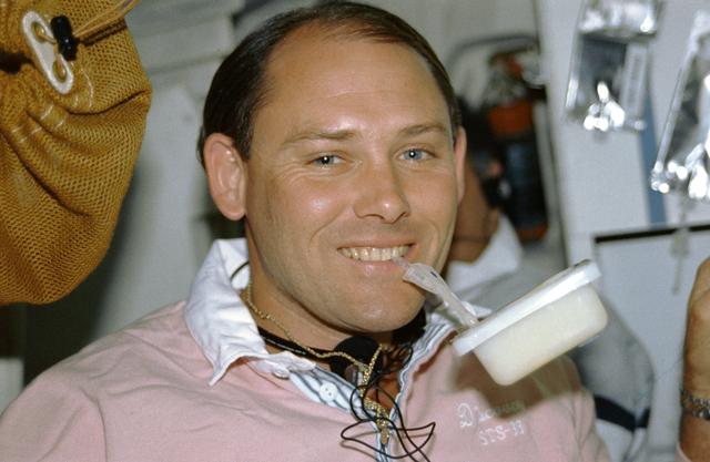 NASA image: STS-33 MS Carter sips drink from a beverage container on OV-103's middeck